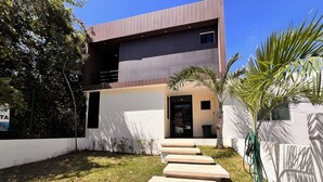 A modern two-story house with a concrete staircase leading to the entrance.