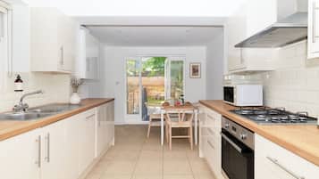 A compact kitchen with a central island, a stove, and a sink.