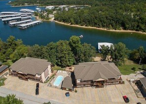 A large building with a swimming pool, surrounded by a parking lot and a body of water. - Lakefront Condo  with Dock Access (Hollister)