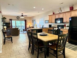 A spacious kitchen with a dining area, wooden cabinets, and a large refrigerator. - Lakefront 3BR condo with resort pool, balcony, and Table Rock Lake views. (Hollister)