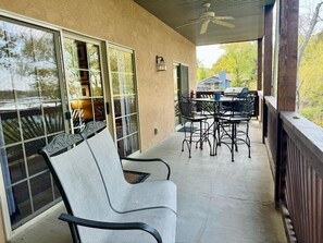 A covered patio with a dining table and chairs, a ceiling fan, and a view of the outdoors. - Lakefront 3BR condo with resort pool, balcony, and Table Rock Lake views. (Hollister)