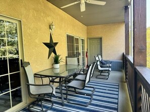 A covered patio with a glass table and chairs, a star decoration, and a potted plant. - Lakefront 3BR condo at Table Rock Lake with pool, patio, and Wi-Fi. (Hollister)
