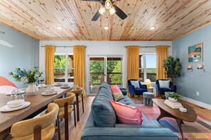 Amplia habitación con comedor, sofá y ventilador de techo.