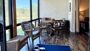 A room with a dining table and chairs, large windows, and a view of the outdoors. - Lakefront 3BR condo at Table Rock Lake with pool, patio, and resort perks. (Hollister)