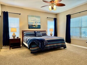 A bedroom with a large bed, two bedside tables, a ceiling fan, and a painting on the wall. - Lakefront 3BR condo at Table Rock Lake with pool, patio, and resort perks. (Hollister)