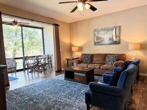 A living room with a sofa, chairs, a coffee table, and a large window. - Lakefront 3BR condo at Table Rock Lake with pool, patio, and resort perks. (Hollister)