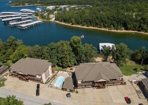 A large building with a swimming pool, surrounded by a parking lot and a body of water. - Lakefront 3BR condo at Table Rock Lake with resort pool and balcony. (Hollister)