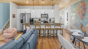 A modern kitchen with white cabinets, stainless steel appliances, and a wooden ceiling. - NEW Disney Lodge 4 min SDC+Hot tub • Sauna • Slide (Branson)