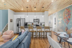 A modern kitchen with white cabinets, stainless steel appliances, and a wooden ceiling. - NEW Disney Lodge 4 min SDC+Hot tub • Sauna • Slide (Branson)