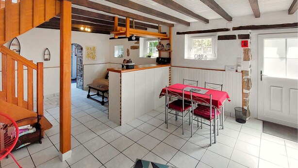A dining area with a red table and chairs, a kitchen area with a counter, and a staircase leading to another level. - Lovely home in Henanbihen with WiFi (Henanbihen)