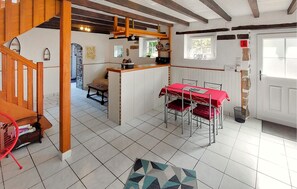 A dining area with a red table and chairs, a kitchen area with a counter, and a staircase leading to another level. - Lovely home in Henanbihen with WiFi (Henanbihen)