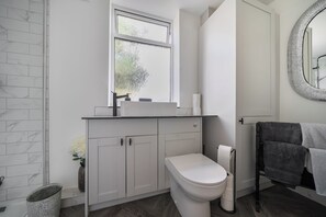 Un bagno moderno con un water, un lavandino e una finestra.