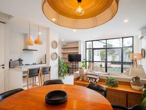 Una cocina moderna con comedor, ventanas amplias y televisor.