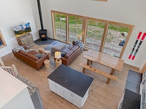 A cozy living room with a fireplace, a sofa, a table, and a TV.