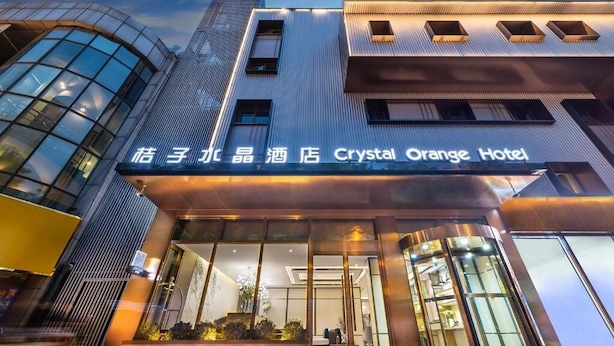 Exterior del Hotel Crystal Orange, con fachada moderna, amplias ventanas y cielo despejado.