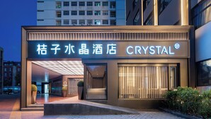A hotel entrance with a modern design, featuring a prominent illuminated sign and a glass facade. - Crystal Hotel Zhongguancun Renmin Univ. (Beijing)