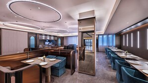 A modern hotel dining area with a long table, booths, and a view of the city. - Crystal Hotel Zhongguancun Renmin Univ. (Beijing)