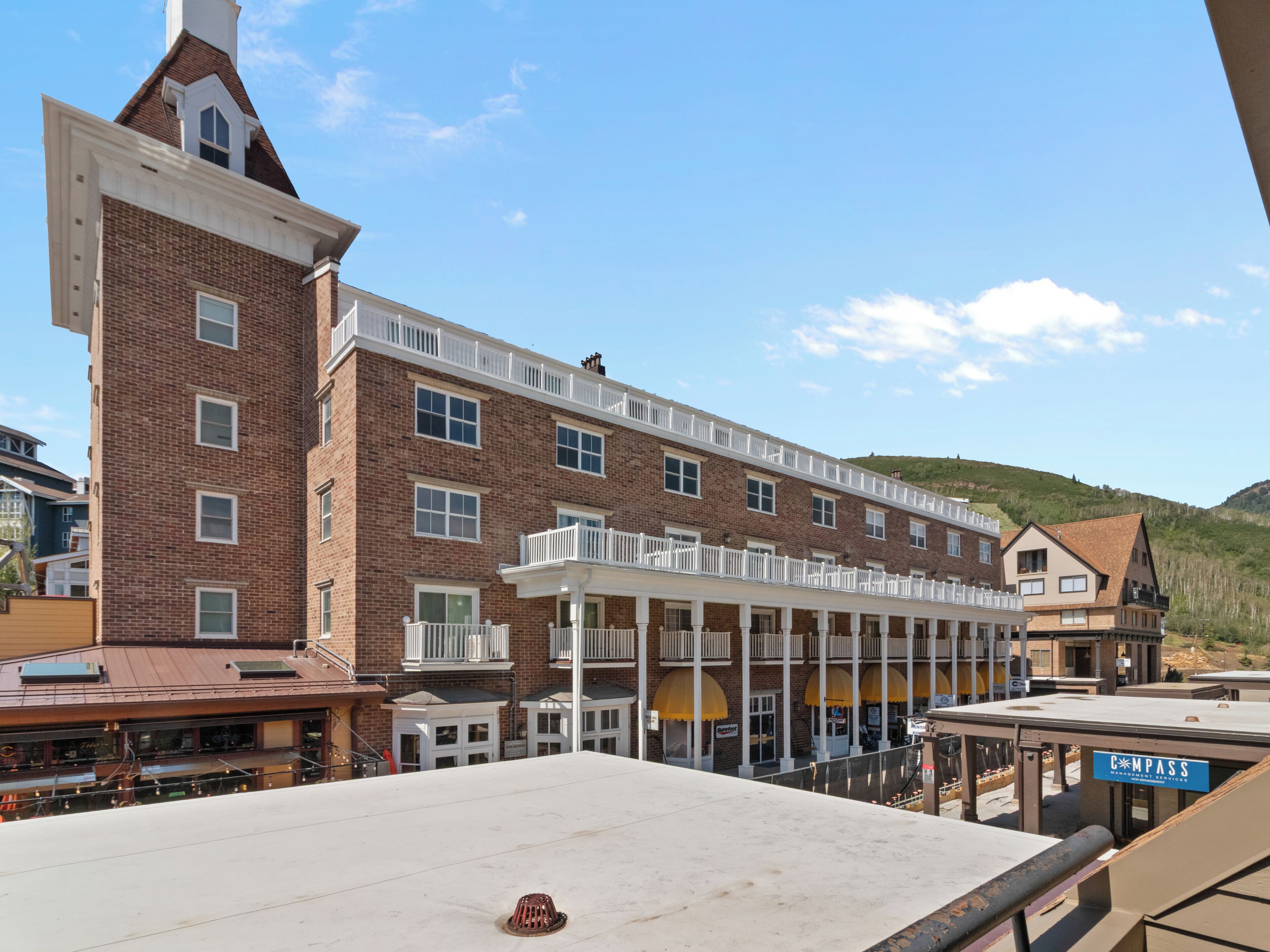 A multi-story hotel with a brick facade, balconies, and a flat roof.