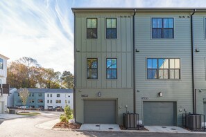 Un immeuble résidentiel à plusieurs étages, doté d’un garage et d’une allée.