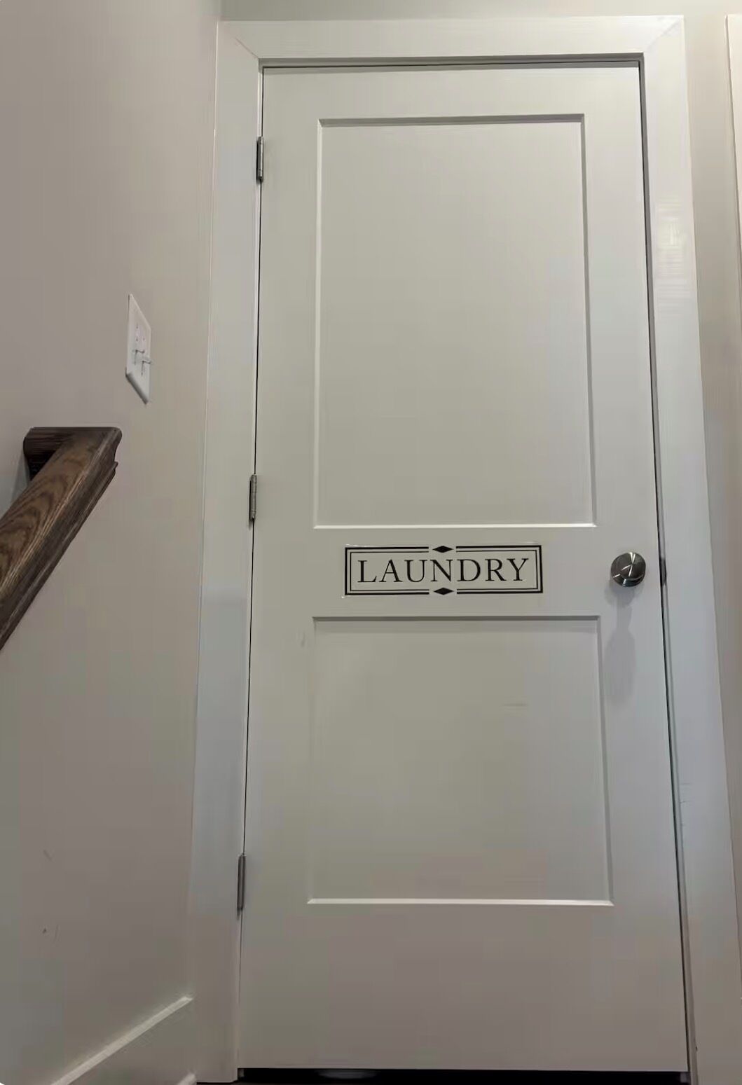 A white door with a 'LAUNDRY' sign above it.