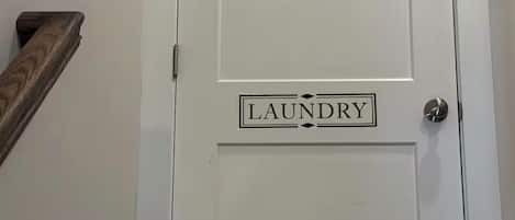 A white door with a 'LAUNDRY' sign above it.