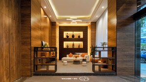 Um interior moderno com balcão de recepção, área de estar e iluminação decorativa.
