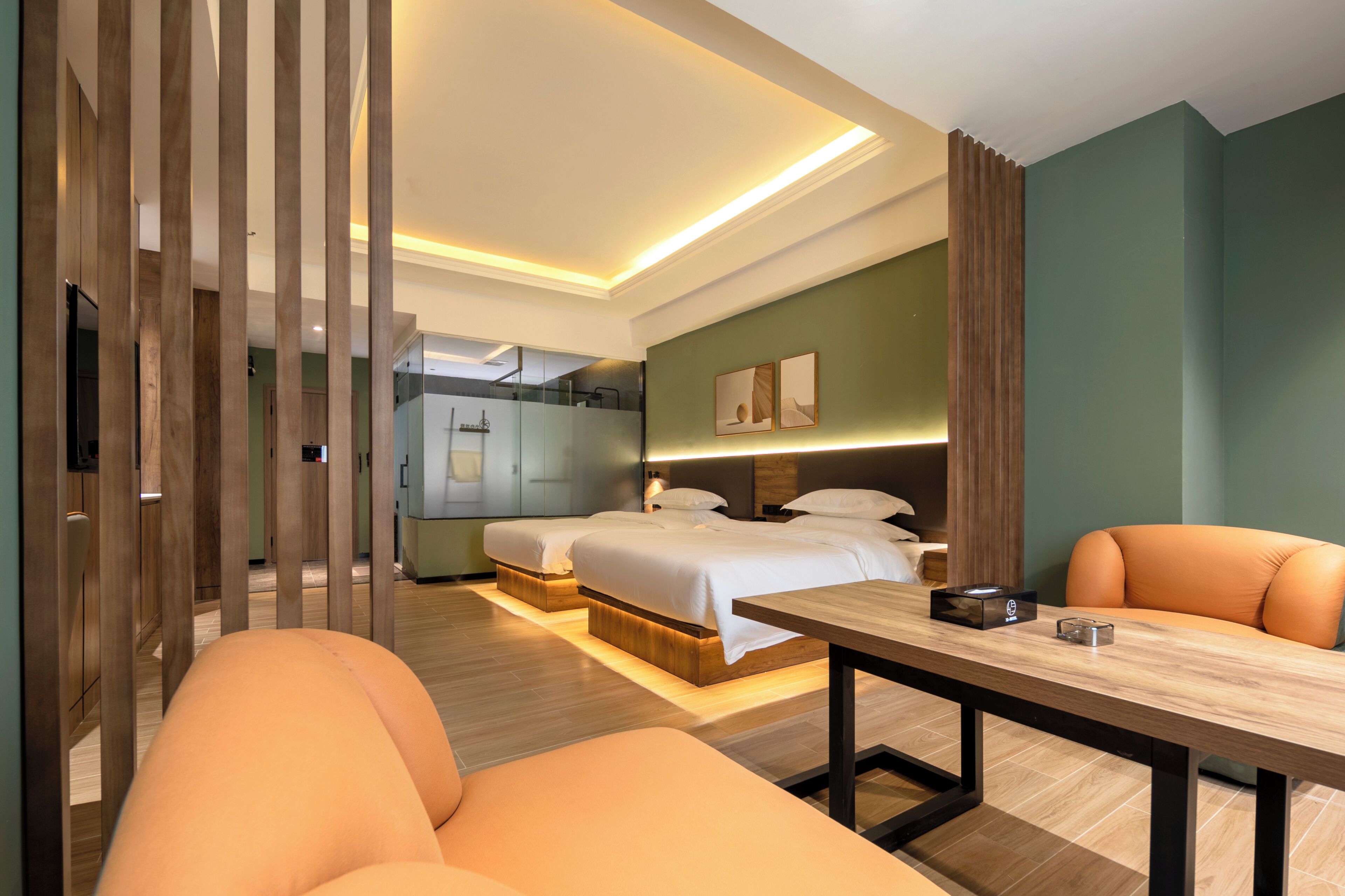 A modern hotel room with a bed, a desk, and a seating area.