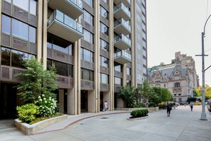 Un immeuble moderne à plusieurs étages, doté de nombreux balcons et d’une cour intérieure.