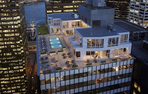 A modern hotel with a rooftop pool, outdoor seating, and a view of the city skyline. - Blueground | Financial District, rooftop pool, nr Brooklyn Bridge (New York)