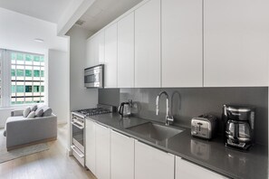 Eine moderne Küche mit Edelstahlgeräten, einer Spüle und einem eingebauten Backofen.