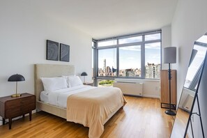 Ein modernes Schlafzimmer mit einem großen Bett, Blick auf die Stadt und einem Oberlicht.