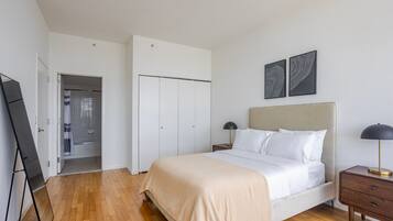 A bedroom with a bed, bedside tables, a wardrobe, and a mirror.