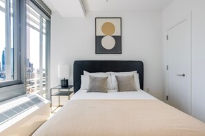 Ein modernes Schlafzimmer mit großem Bett, Blick auf die Stadt und minimalistischer Einrichtung.