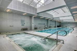 Ein großes Hallenbad mit mehreren Bahnen, einem separaten Ruhebereich und gut erkennbarer Beschilderung zu den Poolregeln.