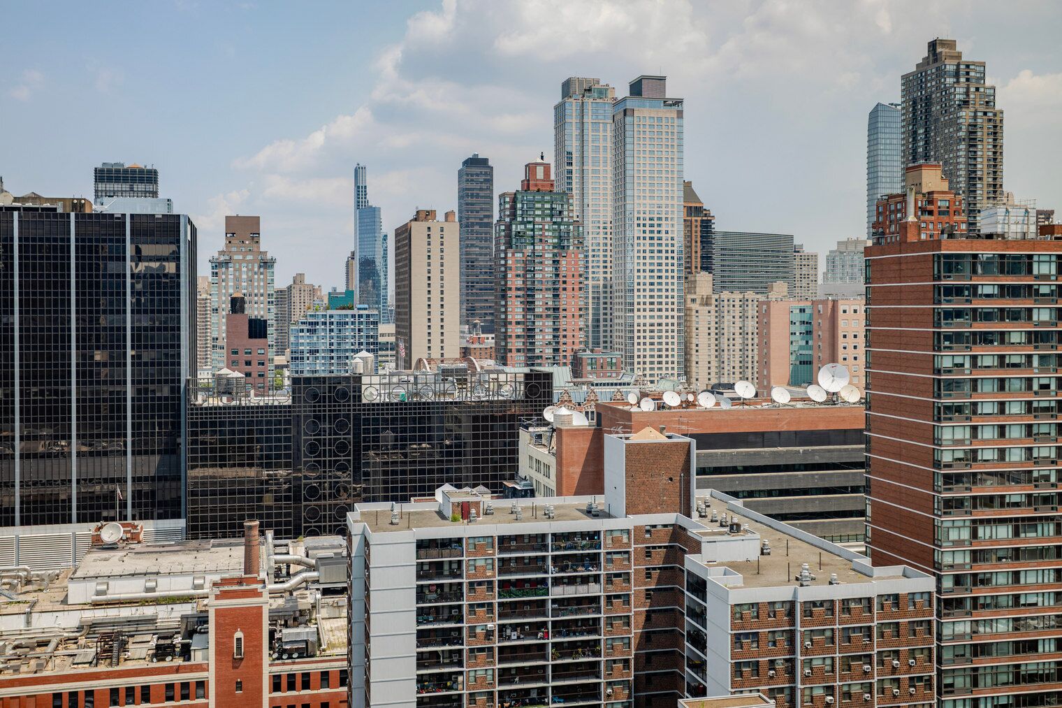 Paisagem urbana com edifícios altos, incluindo uma mistura de fachadas de vidro modernas e estruturas de tijolo mais antigas.