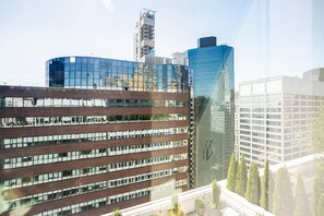 A modern building with a glass facade and a brick structure in the foreground. - Blueground | Financial District, rooftop pool, nr Brooklyn Bridge (New York)
