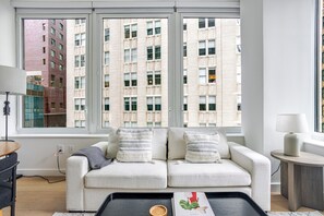Ein stilvolles Wohnzimmer mit einer Couch, einem Couchtisch und einer Lampe.