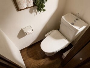 A small bathroom with a toilet, a sink, and a toilet paper holder. - Iki-ju, Hanazono-cho · Accommodates up to 10 people · 1 free parking space · 6-minute walk from Hanazono-cho Subway Station · 5 minutes to Shinsaibashi, Namba, and Nihonbashi (大阪市)