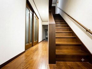 Eine Holztreppe mit Handlauf, die zu einer Zwischenebene führt.