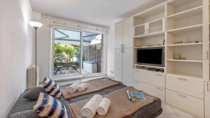 A bedroom with a bed, a TV, and a wardrobe. - Appartement Les Jasmins, Beaulieu sur Mer, France (Beaulieu sur Mer)