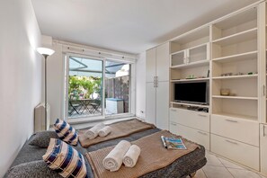 Ein Schlafzimmer mit Bett, Fernseher und Kleiderschrank.