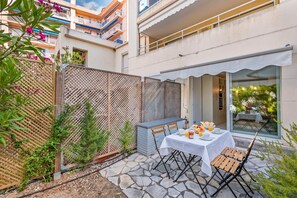 Eine Terrasse mit Frühstückstisch, umgeben von einem Holzzaun und Pflanzen.