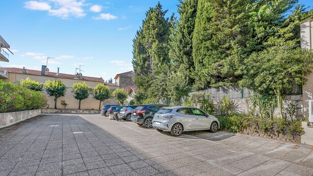 A parking area with several cars parked in a row, surrounded by greenery and buildings. - Appartement Les Jasmins, Beaulieu sur Mer, France (Beaulieu sur Mer)