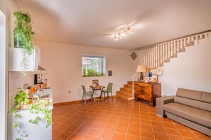 A spacious living area with a staircase, a dining table with chairs, and a sofa. - Casa Floris 3 En-Suite Doubles, Agropoli, Italy (Agropoli)