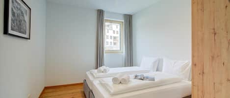 Et hotelværelse med en seng, et vindue og et billede i ramme på væggen.