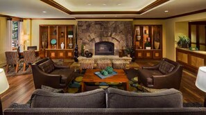 A spacious living room with a fireplace, leather sofas, a coffee table, and a stone accent wall. - 2-Bedroom Condo @ HGVC Valdoro Mountain Lodge, Breckenridge, CO - Christmas Week (Breckenridge)