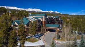 A lodge with multiple buildings, a curved driveway, and snow-capped mountains in the background. - 2-Bedroom Condo @ HGVC Valdoro Mountain Lodge, Breckenridge, CO - Christmas Week (Breckenridge)