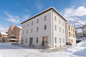 A multi-story building with a flat roof, large windows, and a snow-covered ground. - Residenza Larix 203 San Bernardino Alpine Apartments, San Bernardino, Switzerland (San Bernardino)