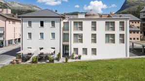 A hotel with a white facade, multiple windows, and a flat roof. - Residenza Larix 002 Modern Alpine Stay In San Bernardino | Ski, Hiking & Nature, San Bernardino, Switzerland (San Bernardino)