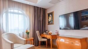 A hotel room with a bed, a desk, a chair, a TV, and a window with curtains. - Vienna Guangzhou Beijing Rd Gongyuanqian (Guangzhou)